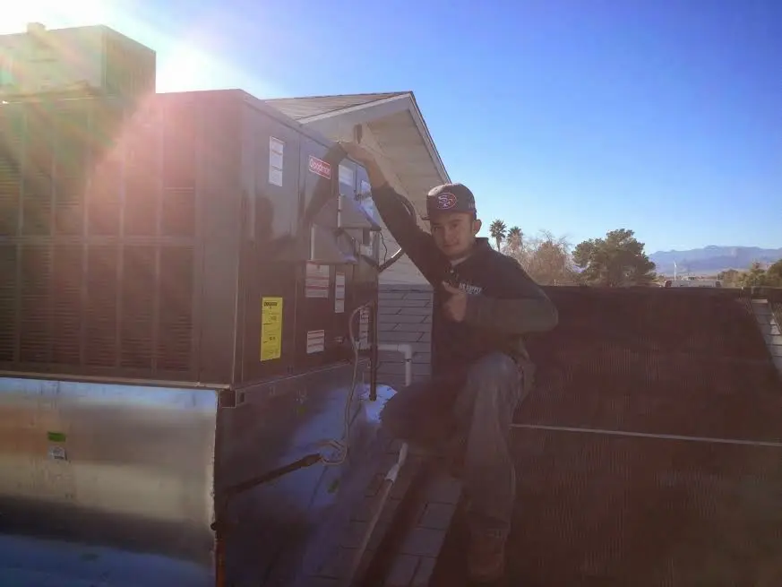 HVAC technician performing Air Duct Repair on a rooftop unit in Forestville